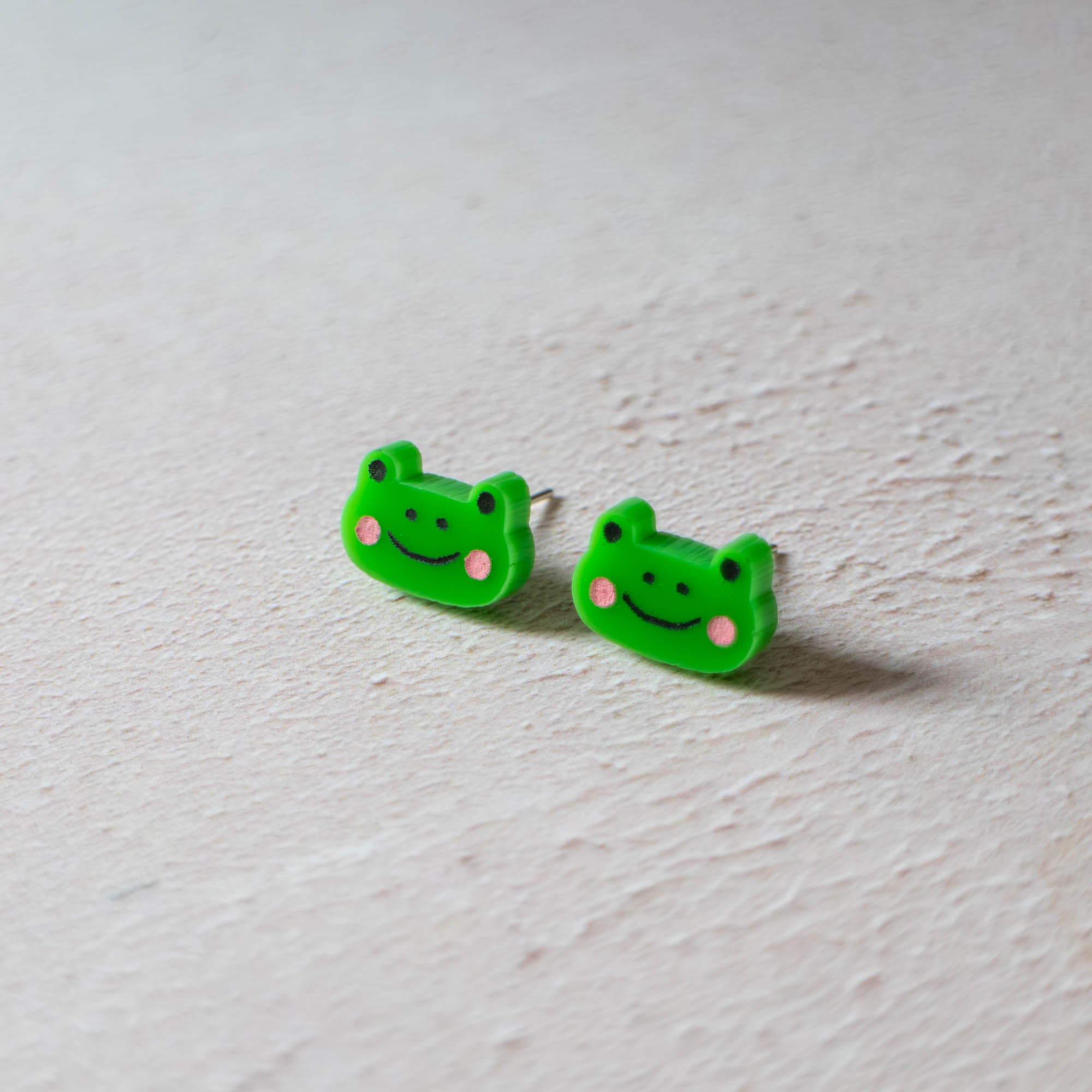 Frog earrings with smiley face by Finest Imaginary